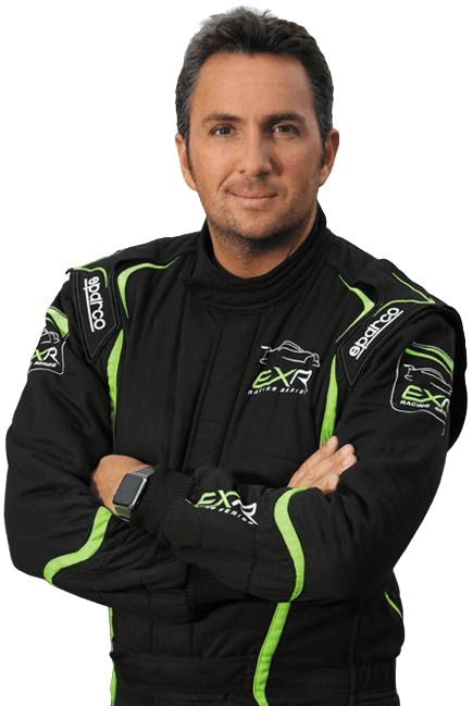 A man in a black and green racing suit with folded arms, set against a white background. He exudes confidence and focus.